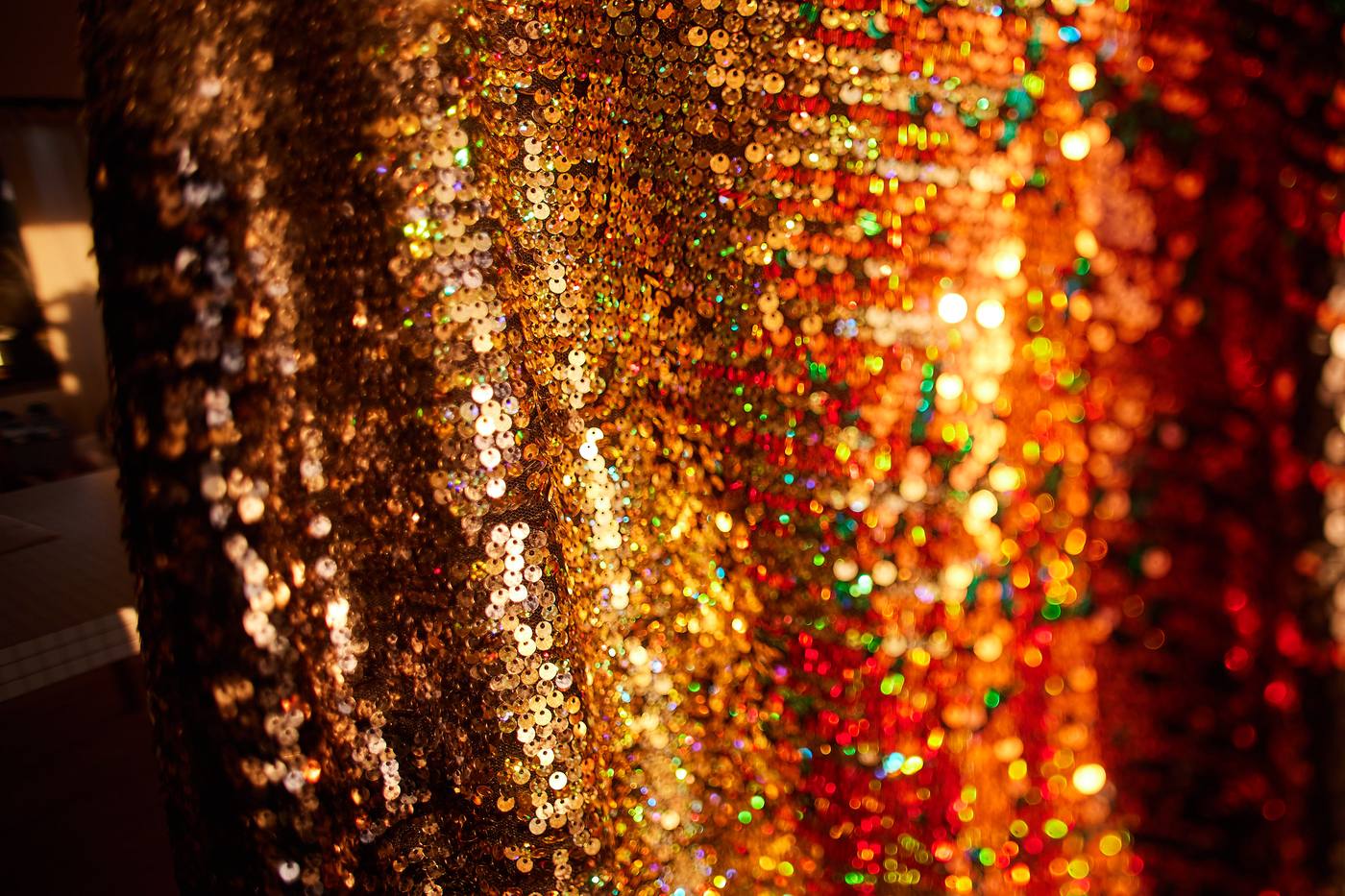 Golden light scattering across a sequinned surface at the celebration
